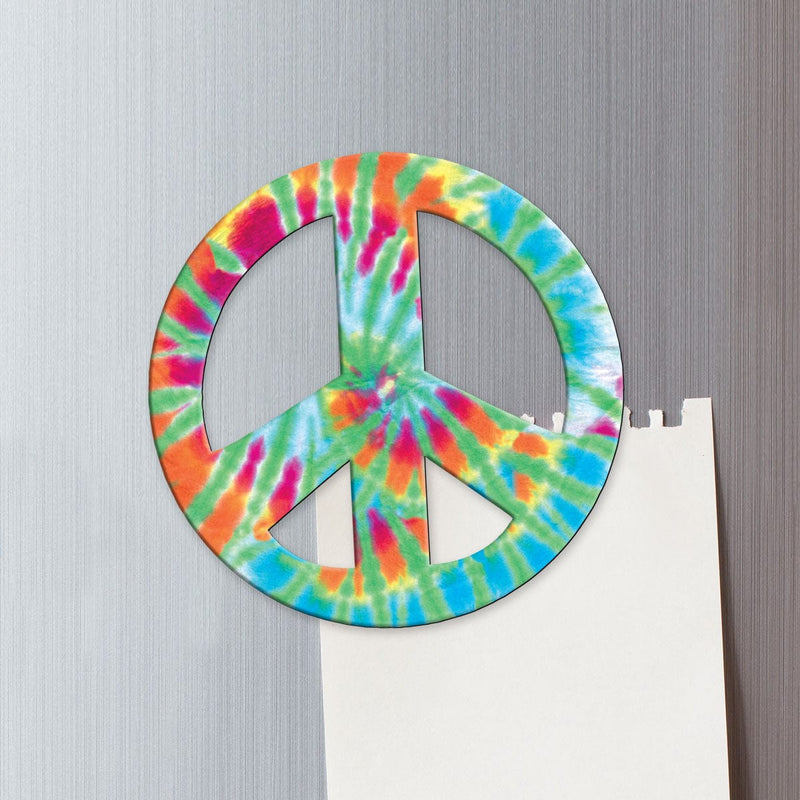 fridge magnet featuring a colorful tie dye peace sign shown on a metal background attached to a torn sheet of memo paper.