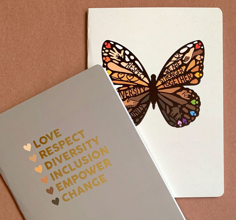 journal notebook set shown overlapping featuring love, respect and diversity depicted in words and a colorful illustrated butterfly.