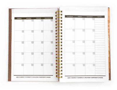 monthly spread of a weekly planner shown open with gold spine, shown on white background.