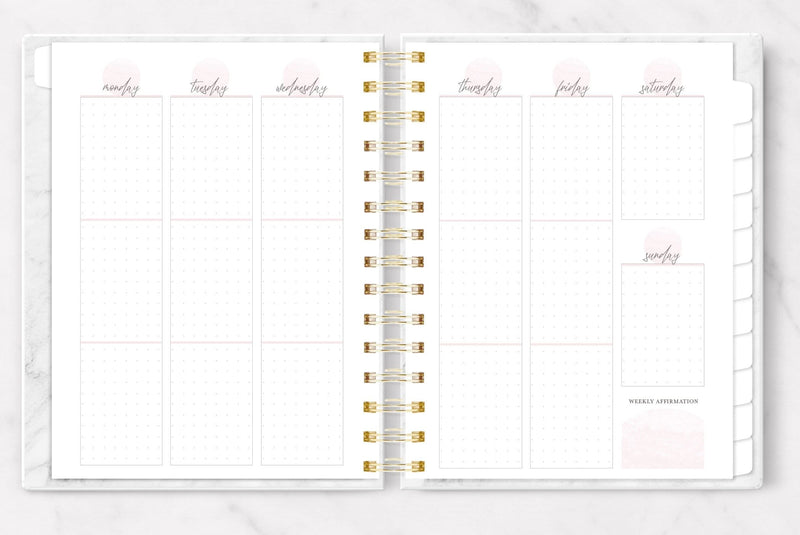 Weekly planner shown open to a light pink and white, dot grid, vertical weekly page spread.