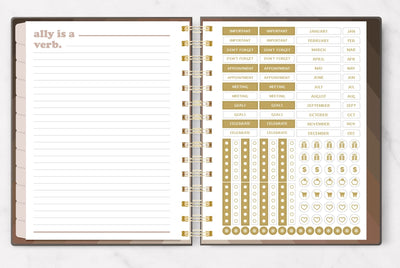 weekly planner featuring inside spread of lined notepaper and gold stickers, shown on white background.