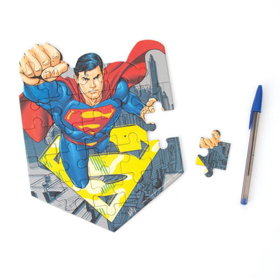 mini die cut jigsaw puzzle featuring superman, shown with pen and one separate piece, on white background.