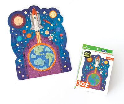 mini die cut jigsaw puzzle featuring an illustrated rocket ship with planets, shown with package on white background.
