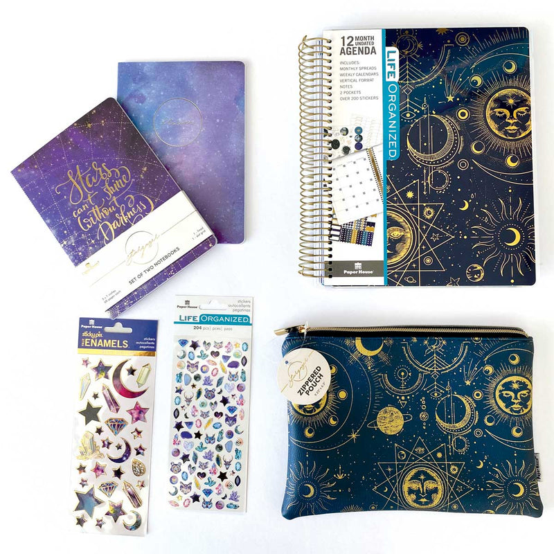 zippered pencil pouch, undated planner, 2 packs of stickers and a notebook set featuring a blue and purple celestial them with gold details are shown on a white background.