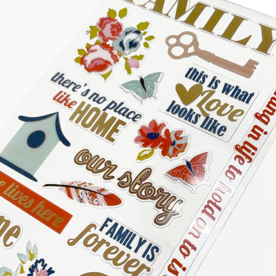 This image of scrapbook stickers shows the family themed sticker sheet on an angle featuring sentiments of love with red and gold details.