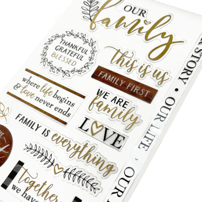 This image of scrapbook stickers shows the family themed sticker sheet on an angle featuring sentiments of love with black and gold details.