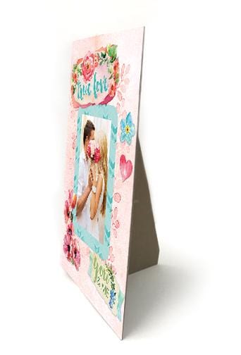 easel back frame featuring a photo of a couple surrounded by teal and pink florals and hearts shown on an angle on a white background.