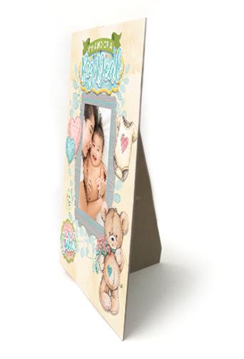 an easel back cardboard frame is shown featuring scrapbook stickers of illustrated bears and hearts shown on an angle on a white background.