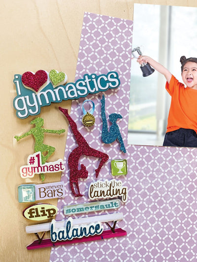 3D scrapbook stickers featuring colorful, glitter silhouettes of gymnasts shown next to a photo of a child holding a trophy.