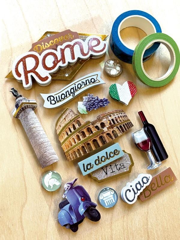3D scrapbook sticker featuring Rome and the colosseum shown next to 2 rolls of washi tape on a wood surface.