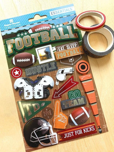 3D scrapbook stickers featuring footballs and helmets shown next to 2 rolls of washi tape on a wood surface.