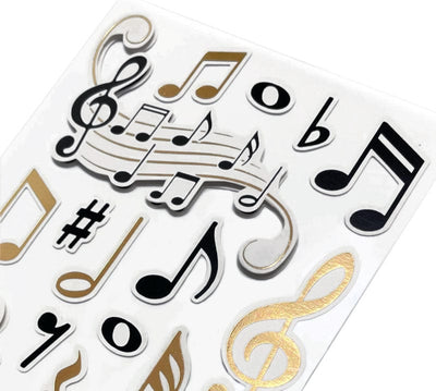 close up of 3D scrapbook stickers featuring gold and black music notes.