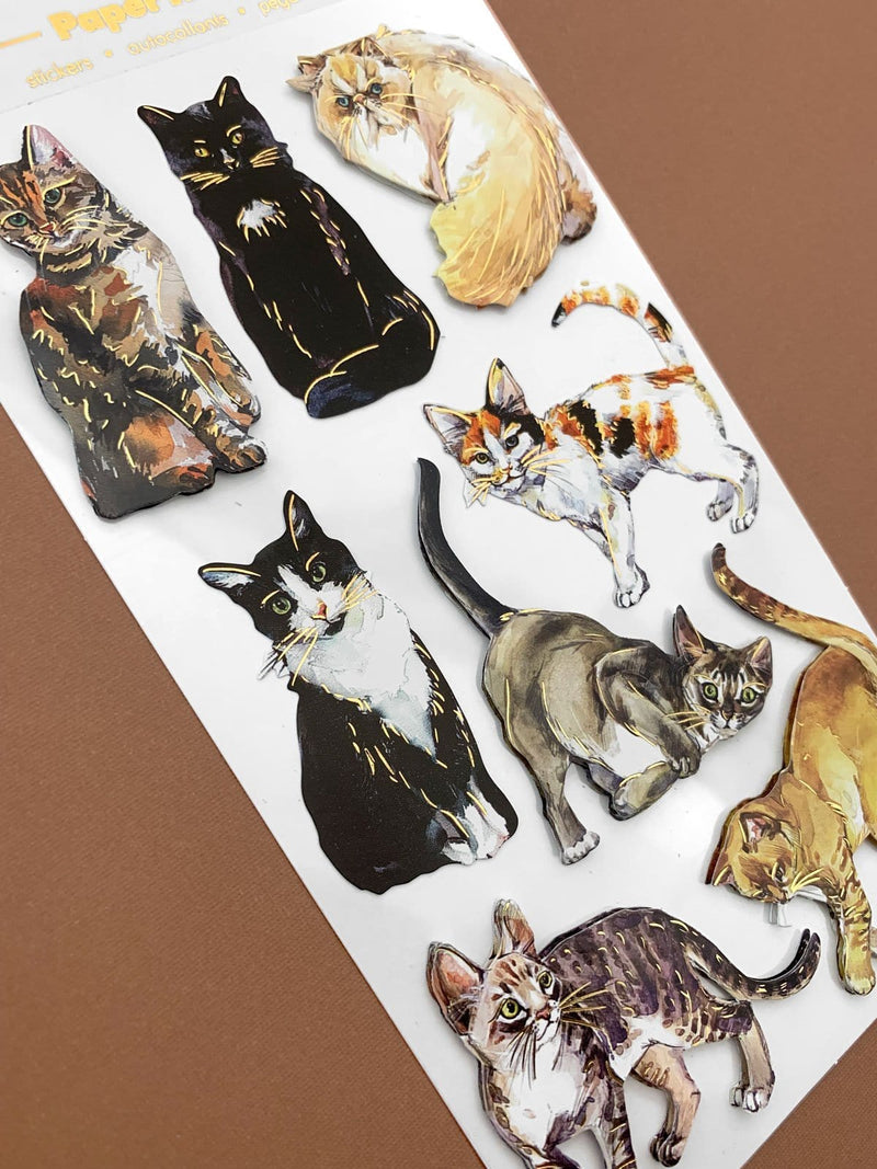 Scrapbook sticker featuring eight assorted cats with gold foil details. Shown in white package with gold foil letters on a brown background.