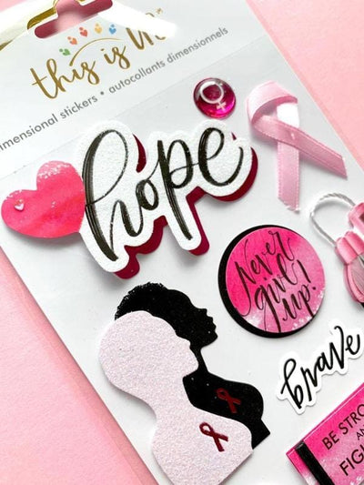 3D scrapbook stickers featuring pink beast cancer awareness ribbons and words of inspiration shown in package on a pink background.