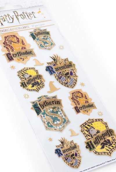 close up of Harry Potter™ foil stickers featuring the house crests with gold accents, shown in package on white background.