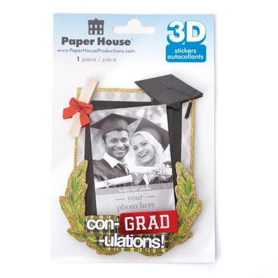3D scrapbook sticker frame featuring a photo of 2 graduates in a frame surrounded by a mortarboard, a diploama and gold glitter accents shown in package on white background.
