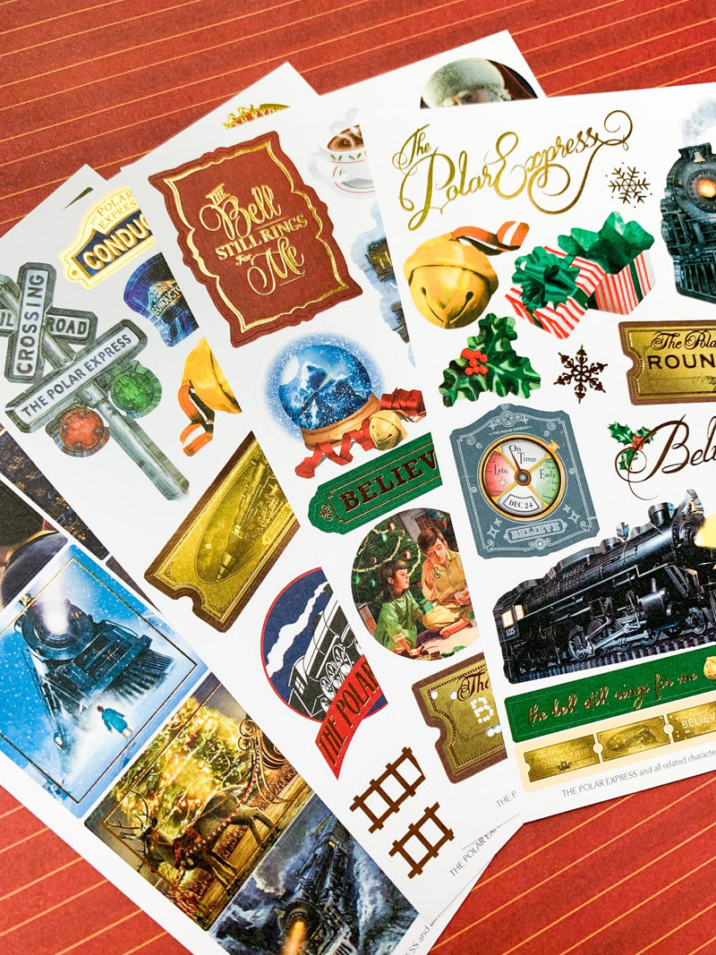 craft kit featuring close up of 4 sticker sheets with scenes and characters from the Polar Express movie, shown overlapping on a red pattern.