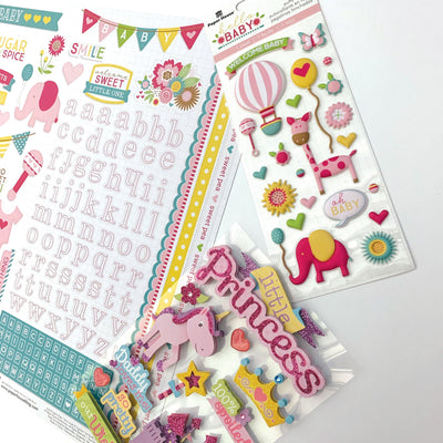An assortment of scrapbook stickers featuring unicorns, pink alphabet, words, balloons and banners with clear glitter details shown displayed on a white background.