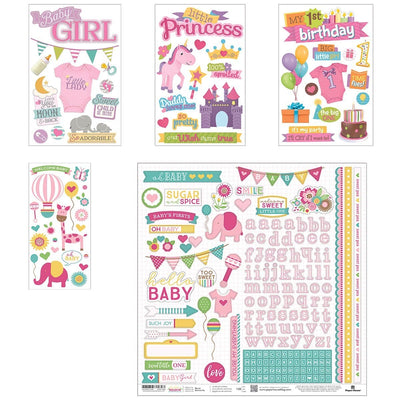 An assortment of baby girl themed scrapbook stickers featuring unicorns, pink alphabet, words, balloons and banners with clear glitter details shown layered on a white background.