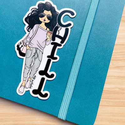 Shaped laptop sticker featuring an illustration of a brunette Lady D with the black letters CHILL stacked beside her, shown on a blue notebook with an elastic band.
