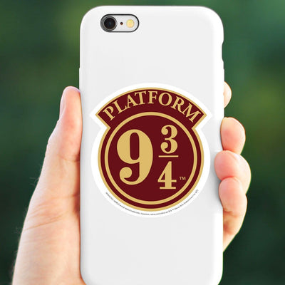 vinyl laptop sticker featuring Harry Potter Platform 9 3/4 sign shown adhered to the back of a white iphone held in a hand.
