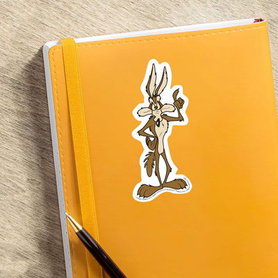 vinyl laptop sticker featuring a diecut Wile E Coyote  shown adhered to orange notebook with pen.