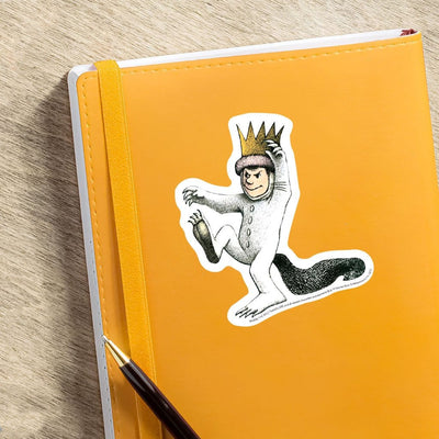 Where the Wild Things Are vinyl laptop sticker featuring a diecut Max shown adhered to orange notebook with pen.
