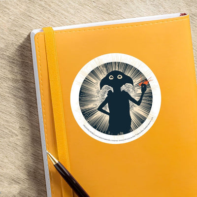 vinyl laptop sticker featuring Dobby Snap shown adhered to orange notebook with pen.