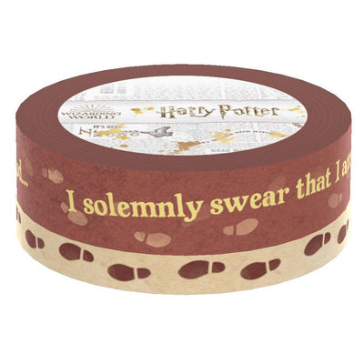 Two rolls of washi tape are shown in packaging featuring "I solemnly swear…" gold lettering on rust colored background and a beige roll with rust colored footprints.