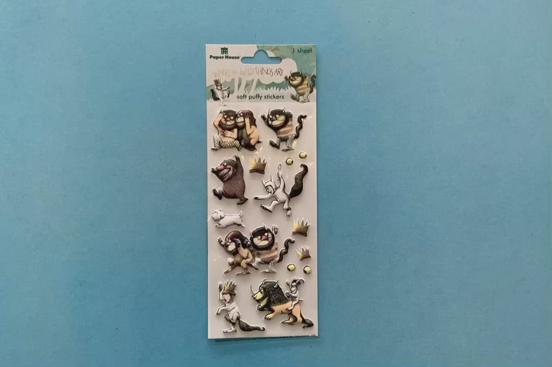 female hands displaying puffy stickers featuring characters from Where the Wild Things Are, on blue background with package.