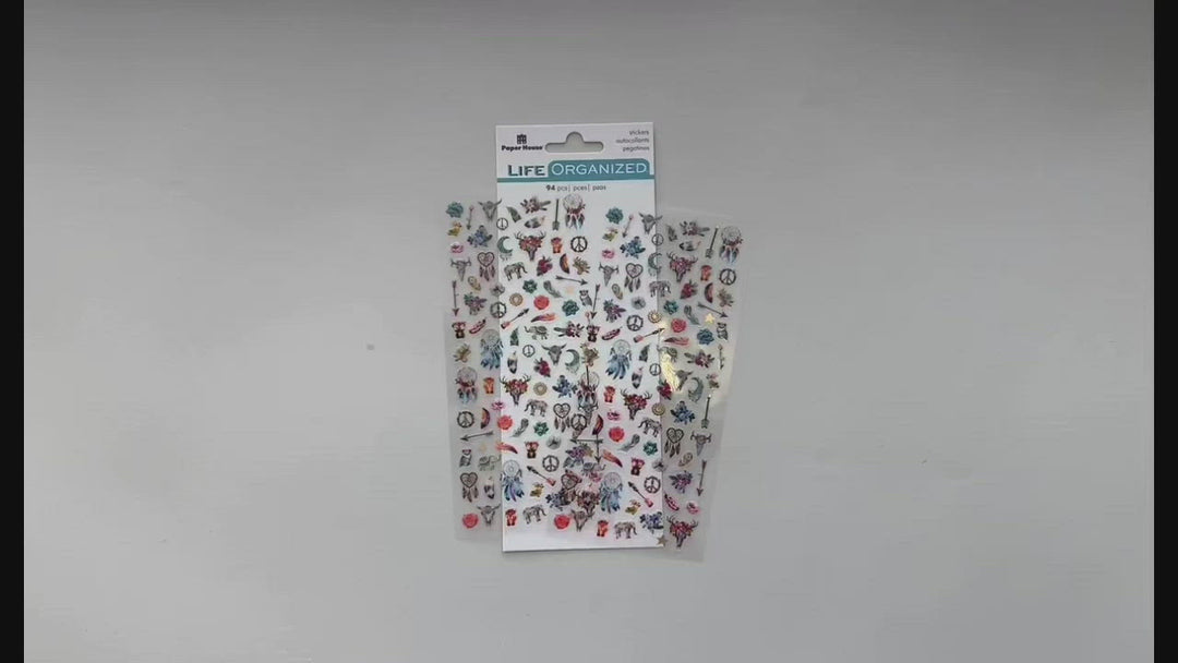 Female hands pick up and show front and back details of mini stickers featuring dream catchers, feathers and directional arrows.