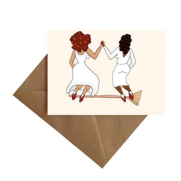 note card featuring an illustration of 2 women jumping the broom, shown with brown envelope on white background.