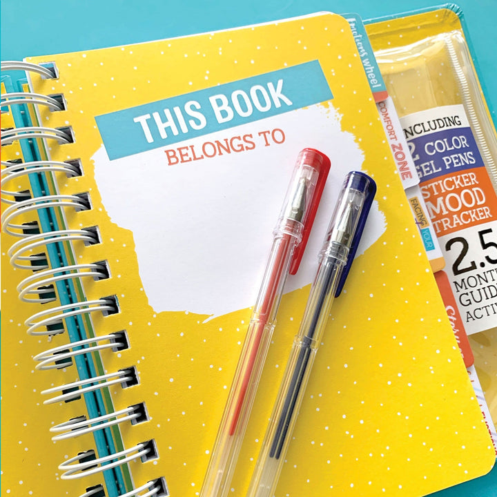 kids journal featuring close up of yellow page with 2 gel pens on teal background.