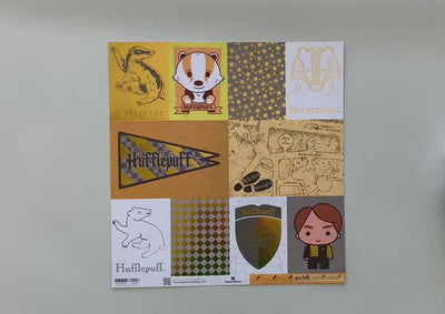 Female hands display Harry Potter scrapbook paper featuring Hufflepuff tags with foil details on one side, and a yellow pattern on the reverse.