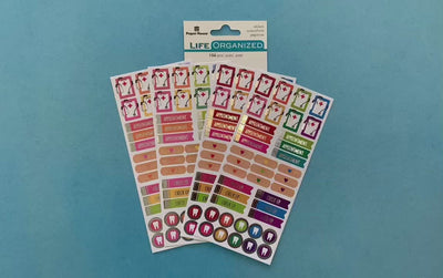 female hands display 4 sheets of planner stickers featuring doctor functional stickers on blue background with package.