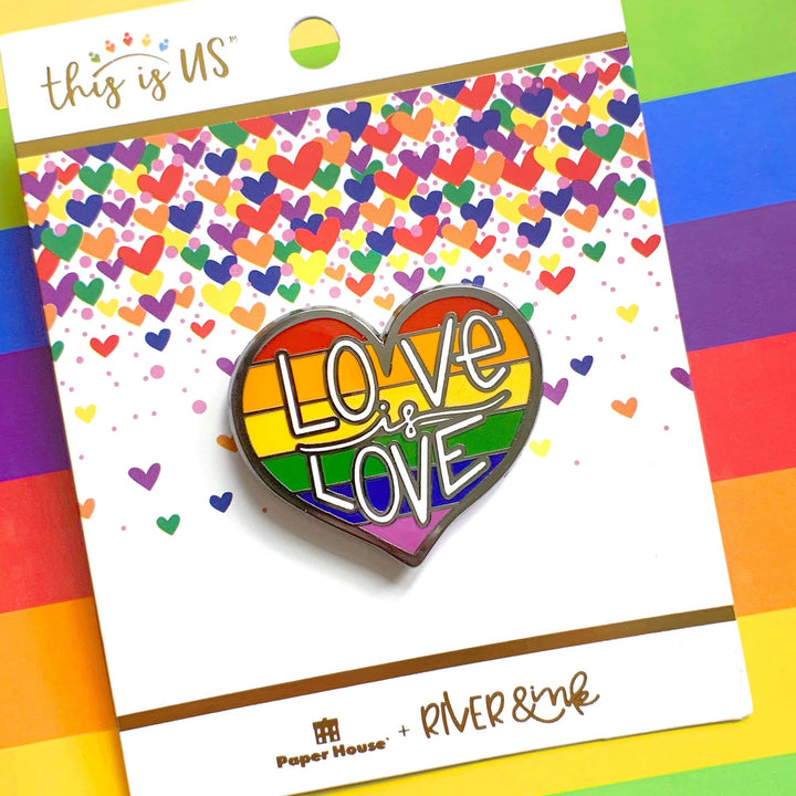 Love is Love enamel pin made of enamel and silver shown in package on rainbow colored background.