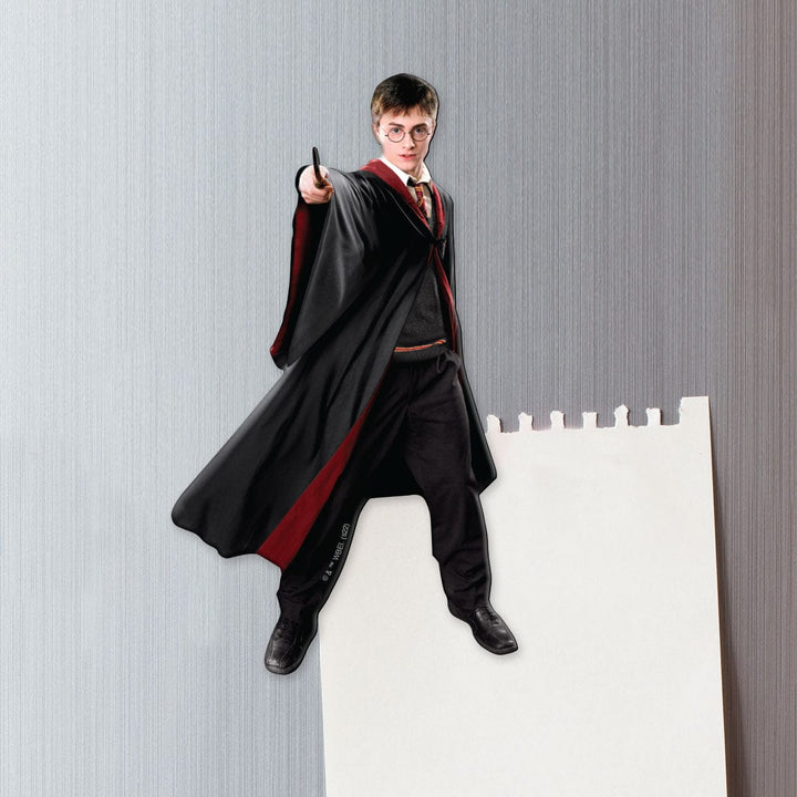fridge magnet featuring Harry Potter performing witchcraft shown on a metal background attached to a torn sheet of white memo paper.