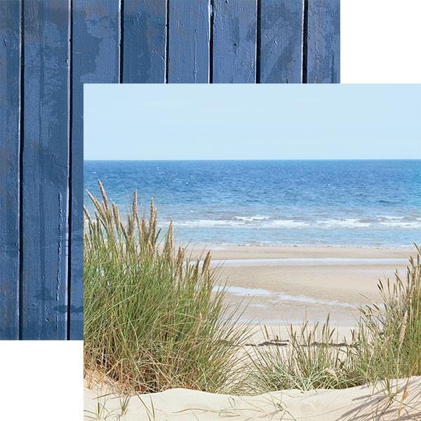 scrapbook paper featuring a photograph of a beach shore in front and a blue wood pattern paper behind.