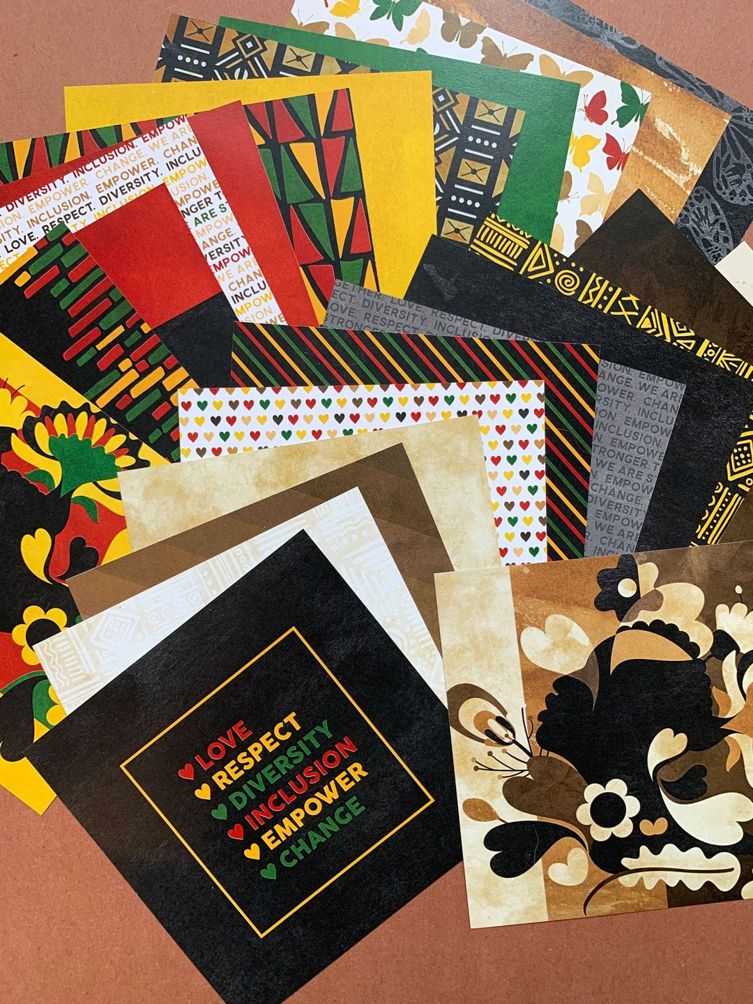 PP-6001E - Scrapbook Paper Pack - Shades of Beauty - Assorted scrapbook papers featuring geometric patterns, floral designs, hearts, and text in red, yellow, green, black, and brown tones