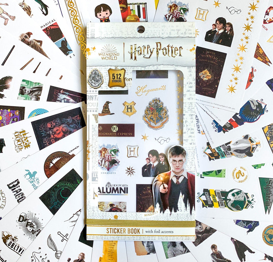 STBK-0008E - Harry Potter Sticker Book - Harry Potter sticker book with 512 foil stickers surrounded by loose Harry Potter-themed stickers and merchandise on white background