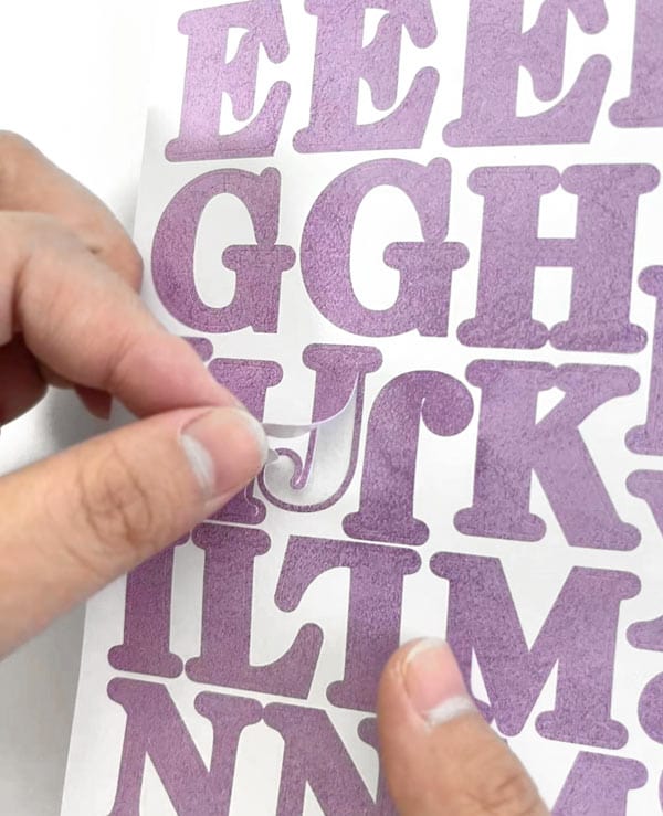 STBK-1001E - Alphabet Stickers - Alphabooks Colorways Serifs - Purple serif alphabet letter stickers being peeled from white backing sheet