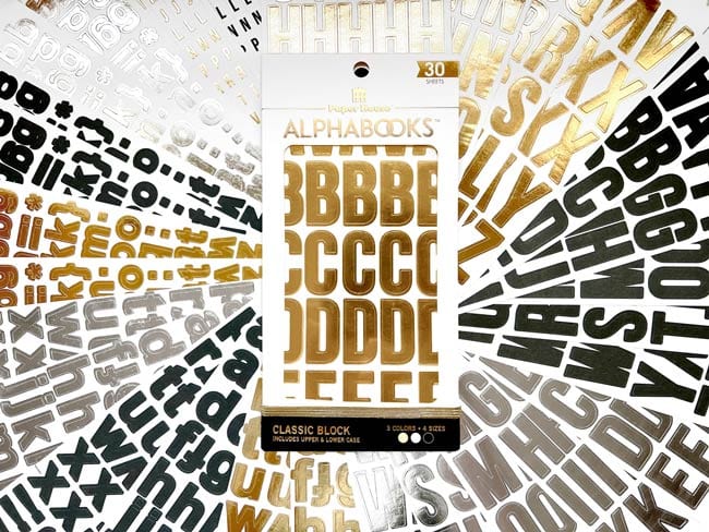 STBK-1002E - Alphabet Stickers - Alphabooks Classic Block - Gold, silver, and black alphabet letter stickers arranged in a fanned display around a central product package