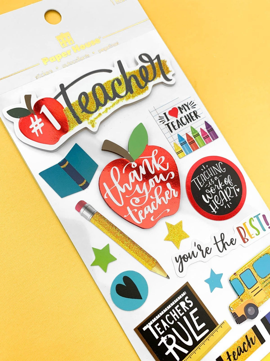 Scrapbook sticker shown in white package on yellow background. These school stickers feature words, apples, crayons and schoolbus.