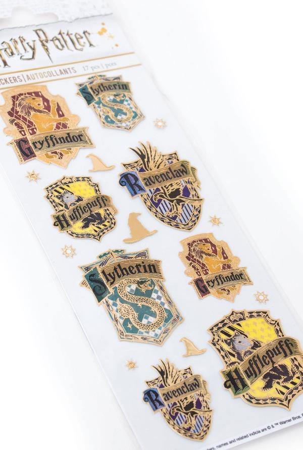 close up of Harry Potter™ foil stickers featuring the house crests with gold accents, shown in package on white background.